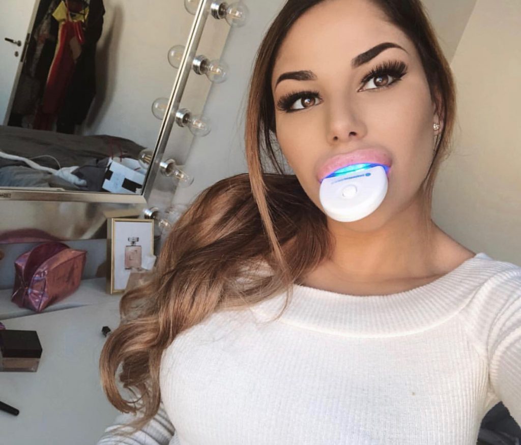 A girl using Belissas Teeth Whitening device